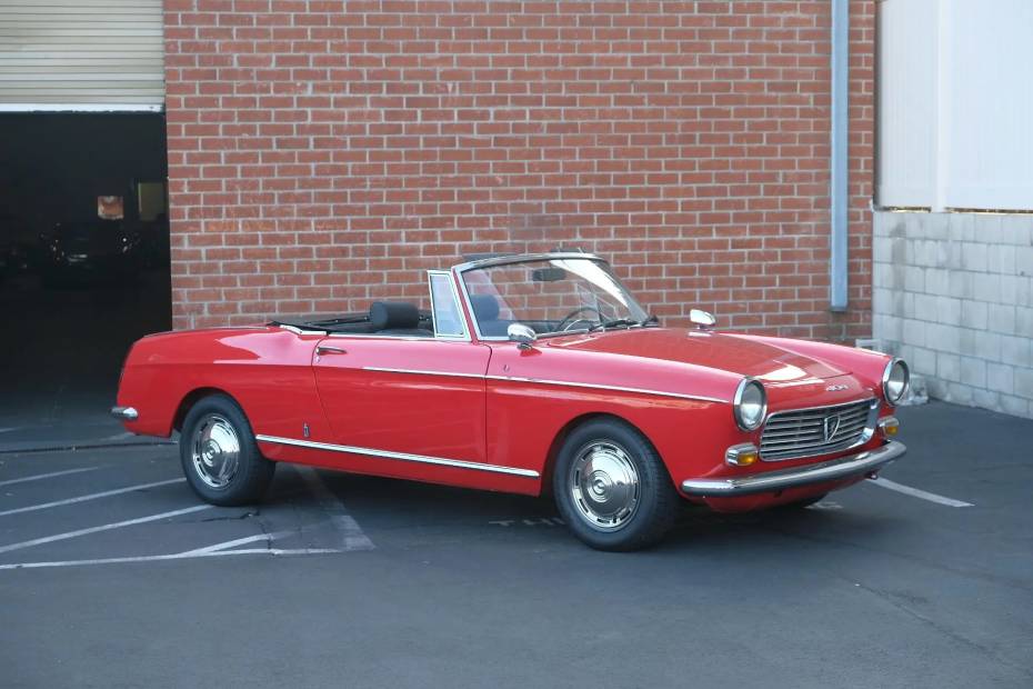 Zdjęcie czerwonego Peugeot 404 Cabriolet przed ceglaną ścianą