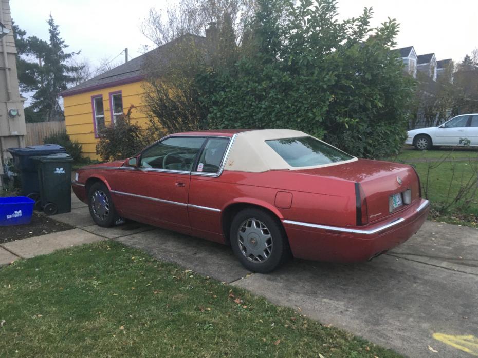 Foto de um Cadillac Eldorado vermelho de 1995 com um teto de vinil bege