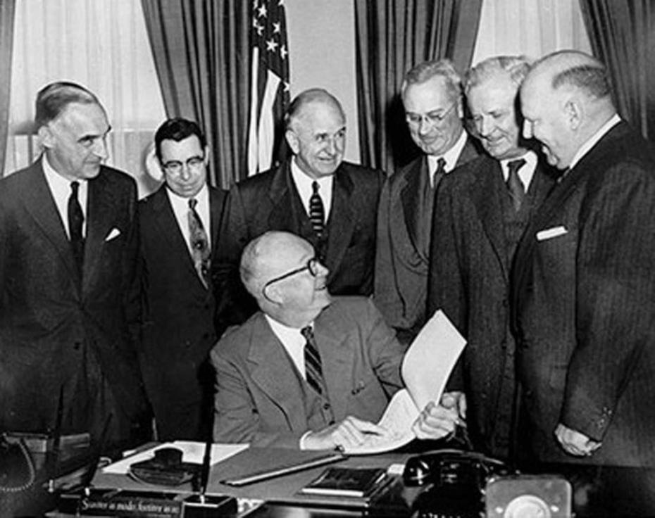 Foto von Dwight D. Eisenhower im Oval Office, umgeben von Männern in Anzügen